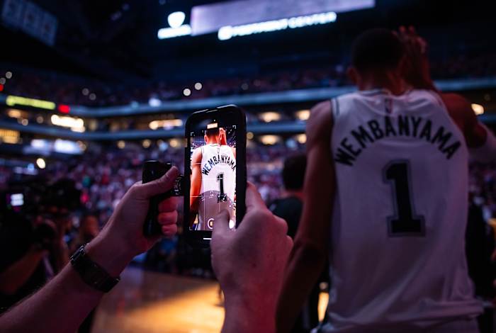 Nov 2, 2023; Phoenix, Arizona, USA; Detailed view as a media member uses an iPhone to film San Antonio Spurs center Victor Wembanyama (1) prior to the game against the Phoenix Suns at Footprint Center.